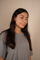 Fototapeta premium Captured from the waist up, this portrait features a woman with long black hair, radiating sophistication. Her relaxed demeanor and direct gaze convey a sense of strength and poise.