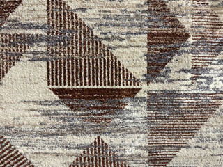 Close up of carpet rug texture in random dirt, triangles, stripes, and grunge texture. In brown,...