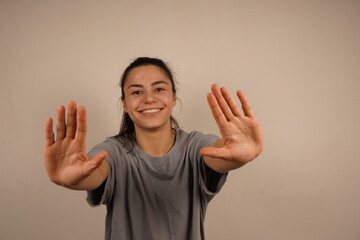 A single hand raised with an open palm delivers a clear "stop" signal. The firm gesture conveys authority and the need to pause. A universal expression of halting action or setting boundaries.