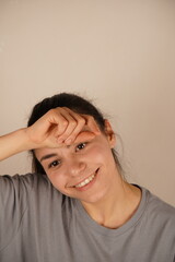 A woman holds her fist to her forehead. This gesture emphasizes alertness and intellectual...