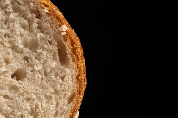 Closeup slice of white bread on black background.