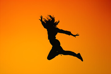 Euphoric Leap: Capturing the Essence of Freedom in a Striking Silhouette Mid-Jump