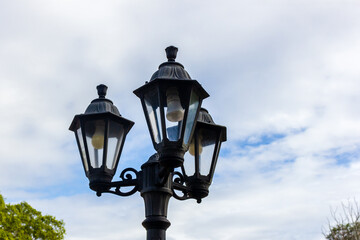 Elegant Black Street Lamp Against a Subtly Cloudy Blue Sky