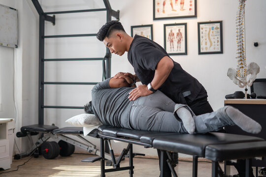 Chiropractic Treatment: A skilled chiropractor provides treatment to a patient on a massage table in a professional office setting, demonstrating a commitment to holistic health and pain management.