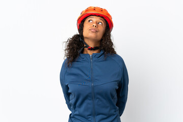 Teenager cyclist woman isolated on white background and looking up