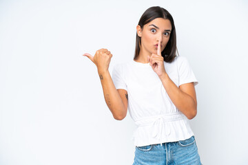 Young caucasian woman isolated on white background pointing to the side and doing silence gesture