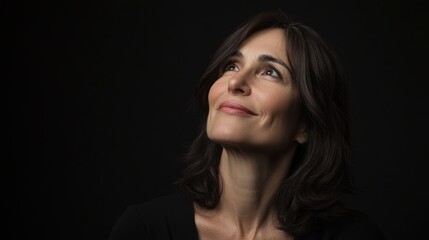 Fototapeta premium Elegant portrait of a woman in black against a dark background