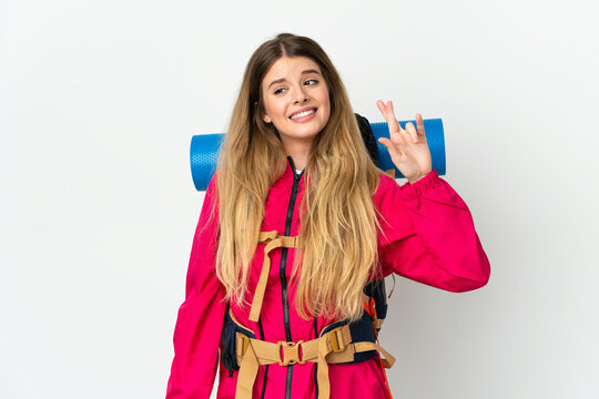 Young mountaineer woman with a big backpack over isolated background with fingers crossing and wishing the best