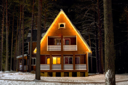 Sharya district, Sharya, Recreation center "New Vetluga Park" - January 29, 2025. Wooden house decorated with garlands in a winter forest. New Year's burning garlands on the house.