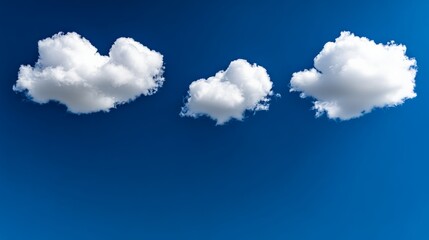 Cloud Formations: A trio of fluffy, white cumulus clouds drift serenely across a vibrant blue sky, their shapes evoking dreams and boundless possibilities.