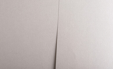 Gray paper background with a metallic, pearlescent finish and overlapping layers. Soft neutral...