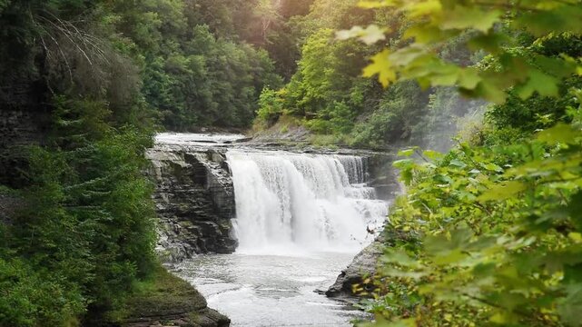 A waterfall is flowing with fresh water cascading down into a stream for a nature travel concept.