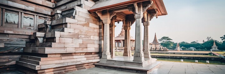Fototapeta premium Ancient stone temple architecture with intricate carvings and a serene water view.