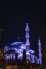 The Sultan Ahmed Mosque, with its domes and six minarets lit in purple and blue, stands against a...
