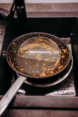 Brudna patelnia leżąca w zlewie