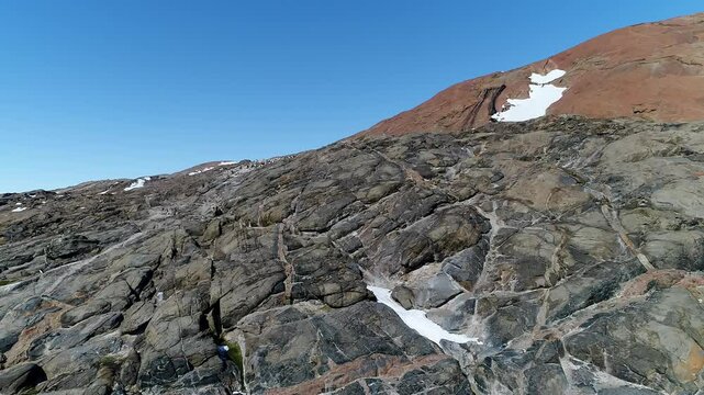 Spring in Antarctica. Summer is coming and melting a snow on the rocks. Open ground warming up under the Sun. Ice in ocean is melting. Aerial shot. Top view.