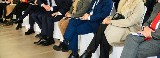 unrecognizable businessman in blue suit speaks into microphones at event