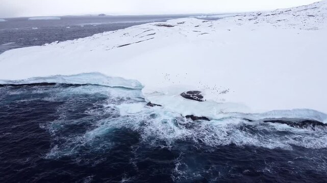 Antarctic spring. South Atlantic Ocean. Waves hitting a glacier. Aerial shot. Ecology in the world. Ice melting protection. 