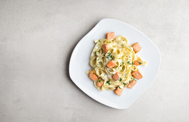Pasta with sauce and baked salmon, top view