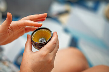 women's hands applying lanolin cream from a jar, designed for soothing and healing breasts after...