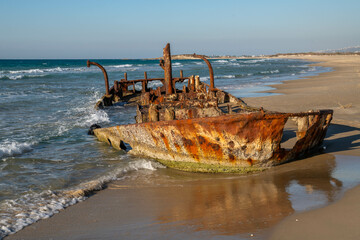Abandoned rusty shipwreck at HaBonim Beach Nature Reserve on the Mediterranean Sea in Israel.
