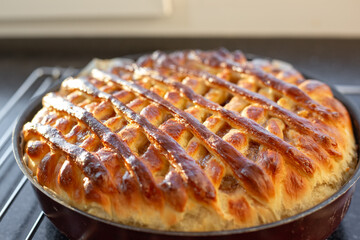 A rich pie with jam, the top crust is made of woven dough in the form of a lattice. Delicious pastry.