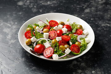 Fresh Mediterranean salad with feta cheese, tomato, olives, onion and basil leaves, Healthy home made food