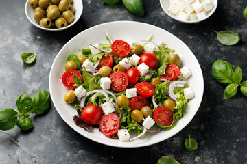 Fresh Mediterranean salad with feta cheese, tomato, olives, onion and basil leaves, Healthy home made food