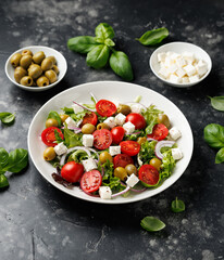 Fresh Mediterranean salad with feta cheese, tomato, olives, onion and basil leaves, Healthy home made food