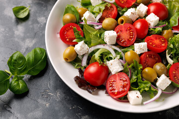Fresh Mediterranean salad with feta cheese, tomato, olives, onion and basil leaves, Healthy home made food