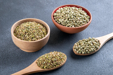 A bowl filled with a pile of natural dried thyme seeds, alongside a spoon containing ground thyme
