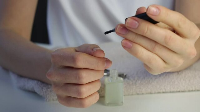 White European woman paints her nails. Home manicure close-up. Beauty care