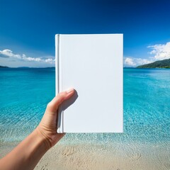 People hands holding a white book mock-up with copy space in front of a beautiful beach