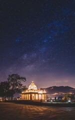 Obraz premium Illuminated temple under a starry night sky. (1)