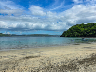 Blanca Beach and the blue waters of Culebra Bay, lush green trees, blue sky and clouds in Liberia Guanacaste Costa Rica