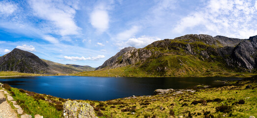 Naklejka premium Breathtaking Panoramic View of Lake Llyn Idwal from a path on the Glyderau Mountain Range in the Ice-Carved Cwm Idwal of North Eryri (Snowdonia)