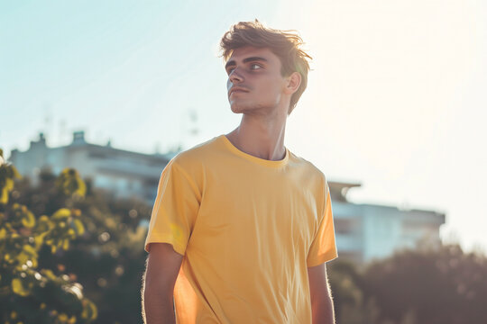 Yellow T-Shirt Mockup Featuring Relaxed Male Model Against Serene Beachside Scenery, Perfect for Summer Fashion and Lifestyle Concepts