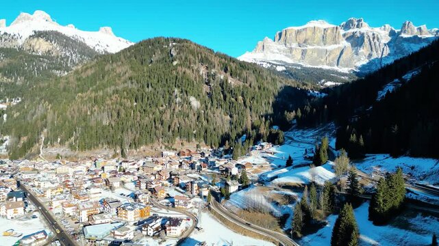 Canazei, a picturesque alpine town in the Dolomites, offers stunning winter landscapes and world-class ski facilities. Surrounded by snow-capped peaks and captured by drone