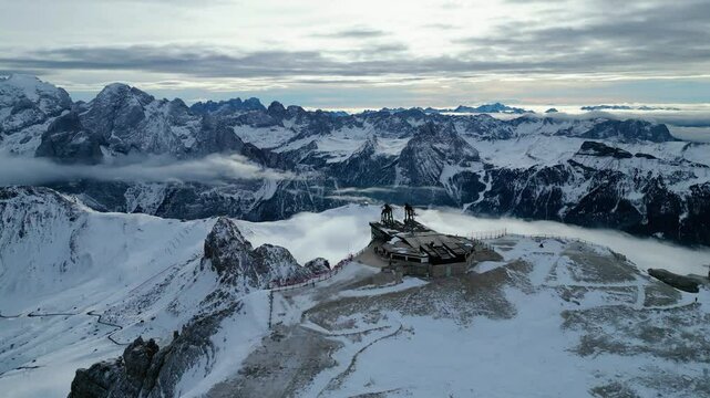 Stazione a Monte - Funivia Sass Pordoi in winter offers an unforgettable experience in the heart of the Dolomites. Captured by drone, the scene showcases the snowy summit station Passo Pordoi below