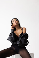 Fototapeta premium Beautiful young Indian woman wears black leather jacket. Vertical.