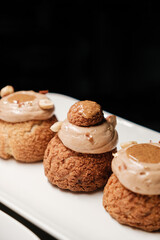 several cakes with nut cream on white tray close-up