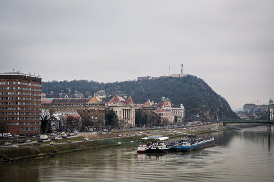 Budapest, Hungary - January 22, 2023: Duna (Danube) waterfront view with Szabads&aacute;g-szobor (Freedom Statue) on the hill, near Műegyetem(University) and Valdemar &eacute;s Nina Langlet rakpart streets