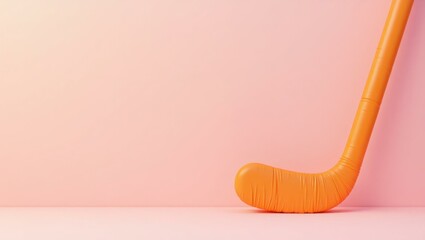Sports Equipment. Orange field hockey stick isolated on pink backgroun