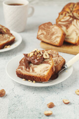 A piece of marble biscuit with chocolate cream and nuts