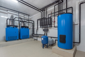 The autonomous gas boiler house is equipped with blue storage tanks and piping systems for...