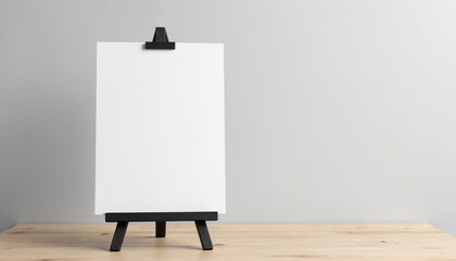 Blank canvas on black easel against neutral background