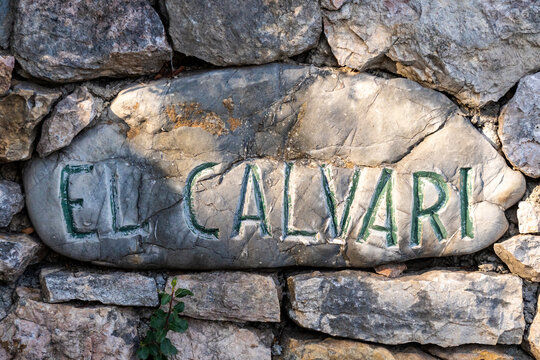 The inscription ' El Calvari ' carved in stone in Pollensa, Mallorca, Balearic Islands, Spain. A stone wall next to the chapel.