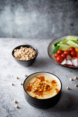 Chickpeas hummus in a bowl with fresh vegetables
