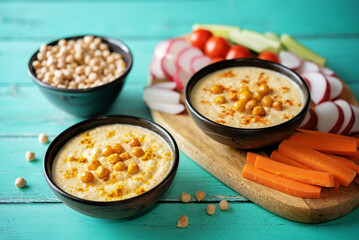 Chickpeas hummus in a bowl with fresh vegetables