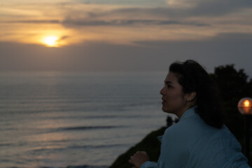 Fototapeta premium Young woman relaxing on boardwalk at sunset after work